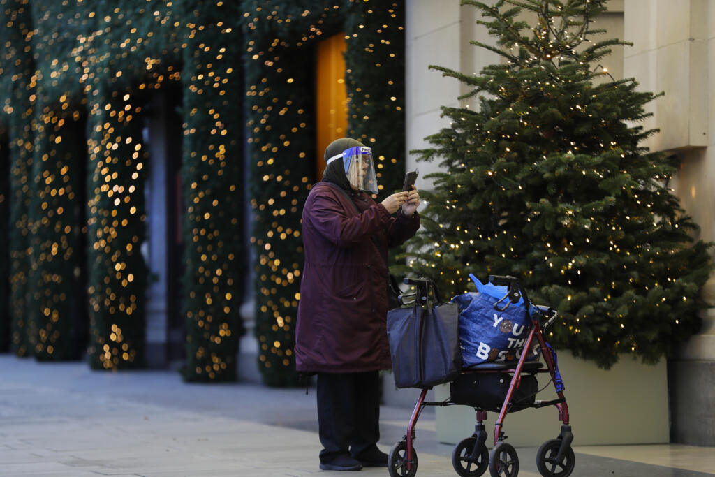 JB 10 Londýn - Žena s ochranným rúškom si fotí vianočnú výzdobu na ulici Oxford Street v Londýne 19. novembra 2020. V Anglicku platí čiastočný lockdown s rozsiahlymi obmedzeniami týkajúcimi sa najmä spoločenských aktivít, ktoré vláda zaviedla v boji proti narastajúcim prípadom ochorenia COVID-19. Nariadenia by mali platiť do 2. decembra, informuje agentúra DPA. FOTO TASR/AP 

A woman photographs Christmas decorations on Oxford Street during a second lockdown in London, Thursday, Nov. 19, 2020. B