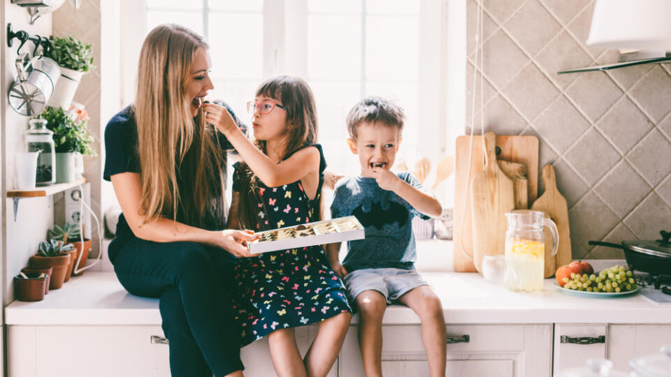 Mom,With,Her,Two,Children,Sitting,On,The,Kitchen,Table