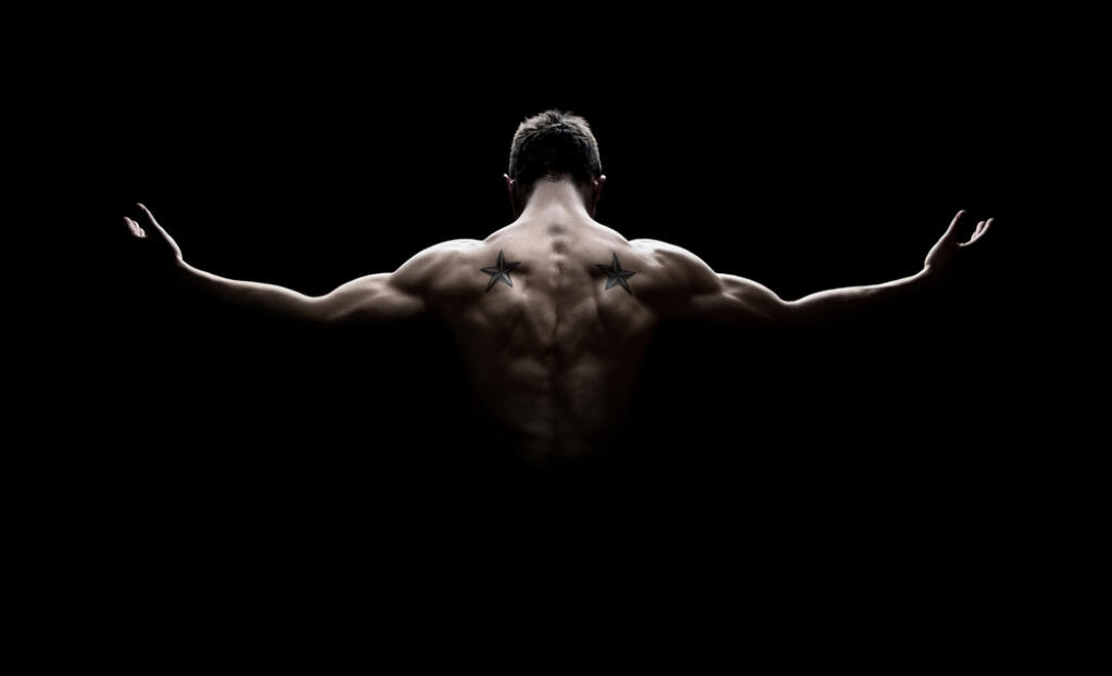 Rear,View,Of,Healthy,Muscular,Young,Man,With,His,Arms