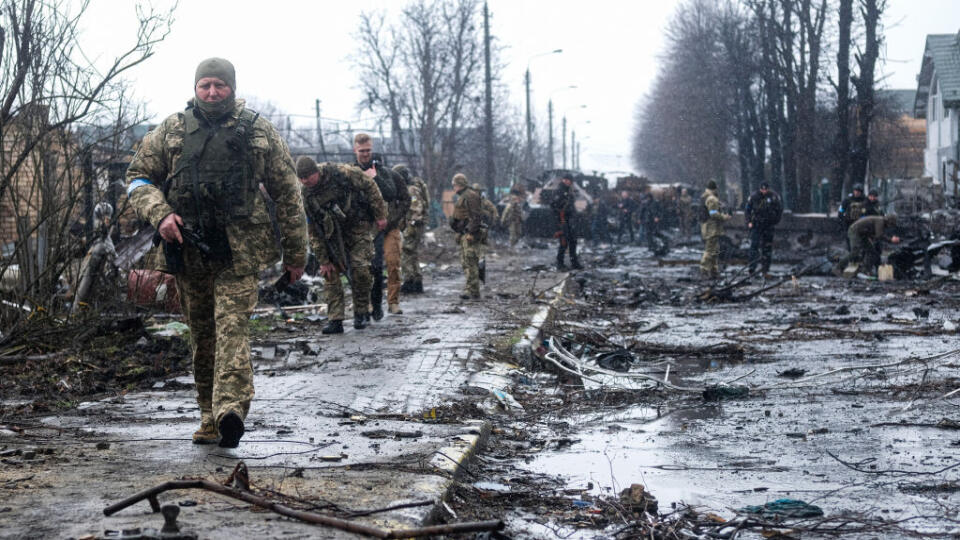 Ukrainian soldiers inspect the wreckage of a destroyed