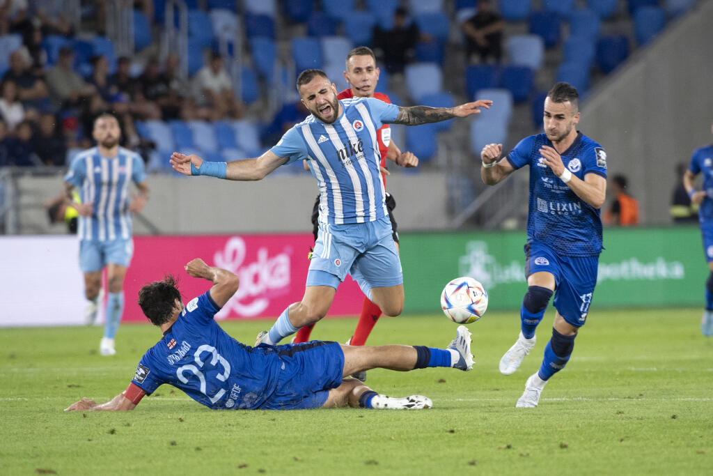 Na snímke uprostred padá Tigran Barseghjan(Slovan), vľavo Mamuka Kobachidze a vpravo Vladimer Mamučašvili (obaja Batumi) v prvom stretnutí 1. predkola Ligy majstrov ŠK Slovan Bratislava - Dinamo Batumi 6. júla 2022 v Bratislave. FOTO TASR - Pavel Neubauer