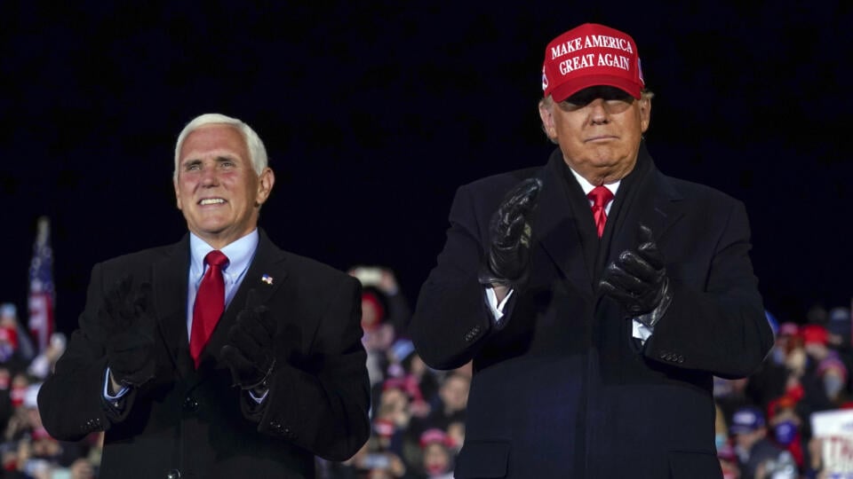 Americký prezident Donald Trump (vpravo) a americký viceprezident Mike Pence tlieskajú na pódiu po ich prejave na predvolebnom zhromaždení v meste Grand Rapids, v americkom štáte Michigen 3. novembra 2020.