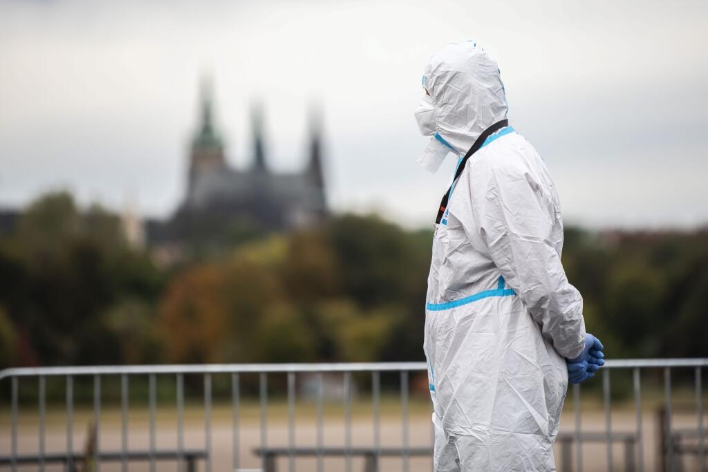 WA 36 Praha - Člen volebnej komisie v špeciálnom ochrannom odeve čaká na voličov, ktorí sú v karanténe na jednom zo stanovíšť počas parlamentných volieb v Českej republike v Prahe v stredu 6. októbra 2021. Voľby do Poslaneckej snemovne Parlamentu Českej republiky sa začali už v stredu. Ako prví môžu hlasovať ľudia, ktorí sa pre koronavírus nachádzajú v karanténe alebo izolácii. Tí môžu svoj hlas odovzdať priamo zo svojho auta na jednom z 82 stanovíšť. Oficálne sa volebné volebné miestnosti otvor