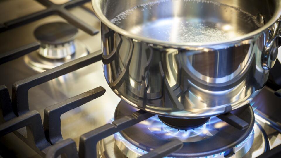 Pot on stove with gas burner and flame