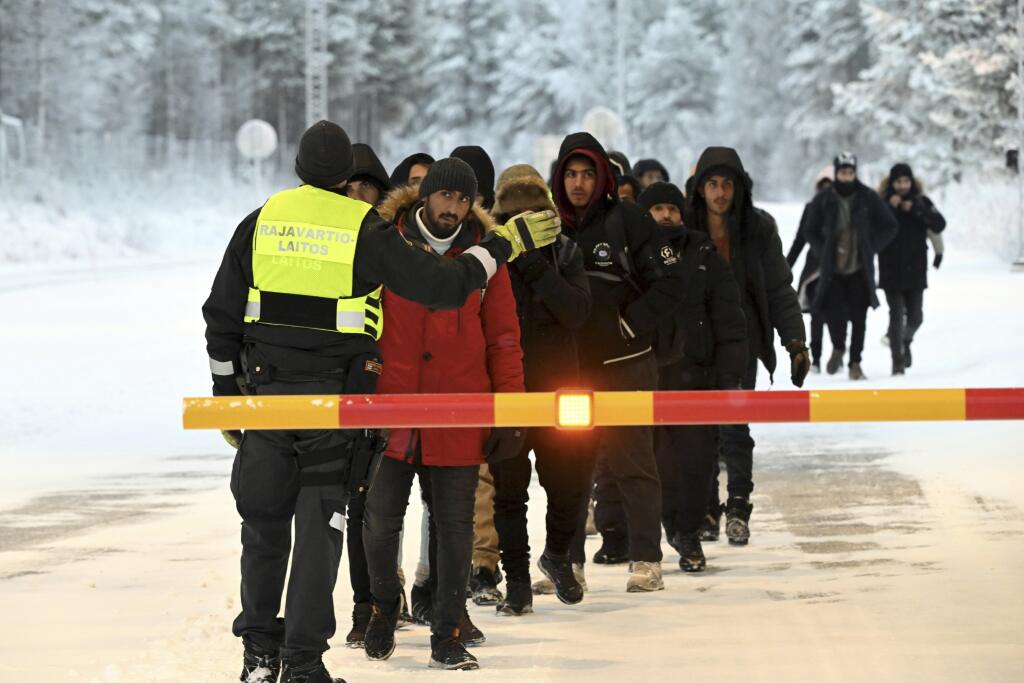 JB 43 Salla - Príslušník fínskej pohraničnej stráže hovorí s migrantmi, ktorí prichádzajú na medzinárodnú hranicu medzi Fínskom a Ruskom, vo fínskom pohraničnom meste Salla 23. novembra 2023. Agentúra Európskej únie pre pohraničnú a pobrežnú stráž (Frontex) vyšle svoj 50-členný tím do Fínska, ktoré čelí prílevu nelegálnych migrantov na hranici s Ruskom. Očakáva sa, že posily budú vo Fínsku pôsobiť už od budúceho týždňa, informovala vo štvrtok agentúra AFP. Fínsko už minulý týždeň uzavrelo v reak