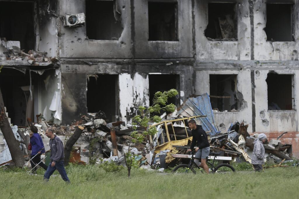 PK 27 Mariupol - Ľudia kráčajú okolo zničených budov v Mariupole na juhovýchode Ukrajiny v sobotu 21. mája 2022. FOTO TASR/AP

People walk past a destroyed building in Mariupol, in territory under the government of the Donetsk People's Republic, eastern Ukraine, Saturday, May 21, 2022. (AP Photo/Alexei Alexandrov)