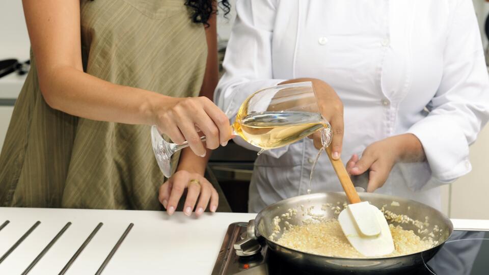 Woman pouring white wine in pan