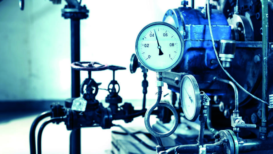 Closeup of manometer, pipes and faucet valves of heating system in a boiler room