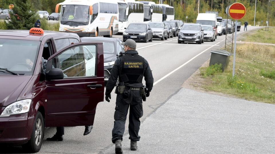 Príslušník fínskej pohraničnej stráže kontroluje osobné vozidlo s ruskou štátnou poznávacou značkou na fínsko-ruskom hraničnom priechode Vaalimaa v nedeľu 25. septembra 2022.