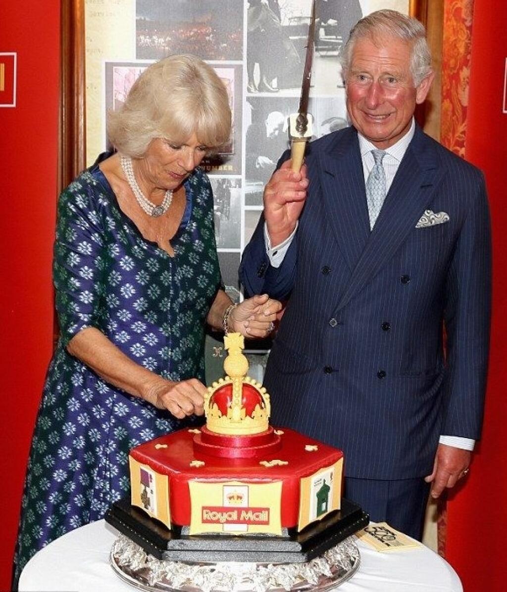 Camilla a Charles krájajú tortu pri príležitosti 500.výročia kráľovskej pošty.