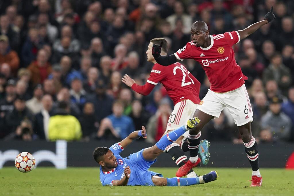 Futbalista Manchestru United Paul Pogba (vpravo) a hráč Atletica Madrid Renan Lodi bojujú o loptu v odvetnom osemfinálovom zápase Ligy majstrov Manchester United - Atletico Madrid v Manchestri v utorok 15. marca 2022.