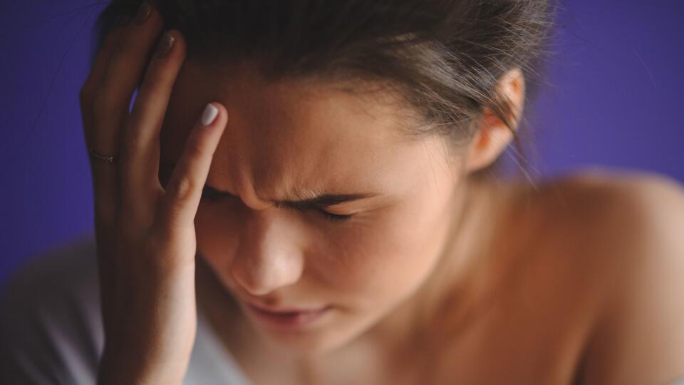 Teen woman with headache holding her hand to head