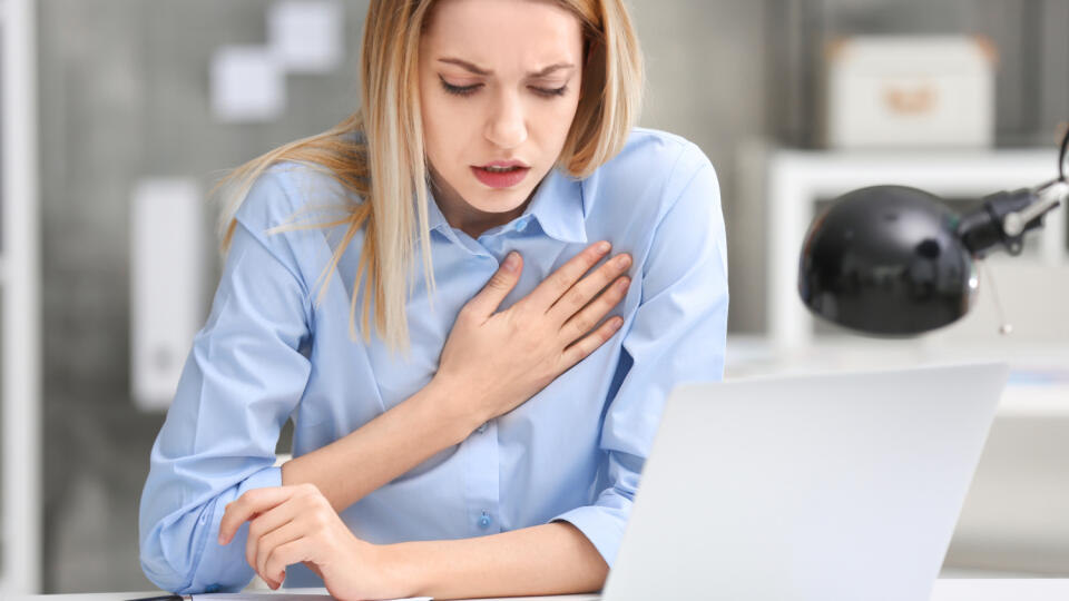 Young,Woman,Suffering,From,Chest,Pain,In,Office