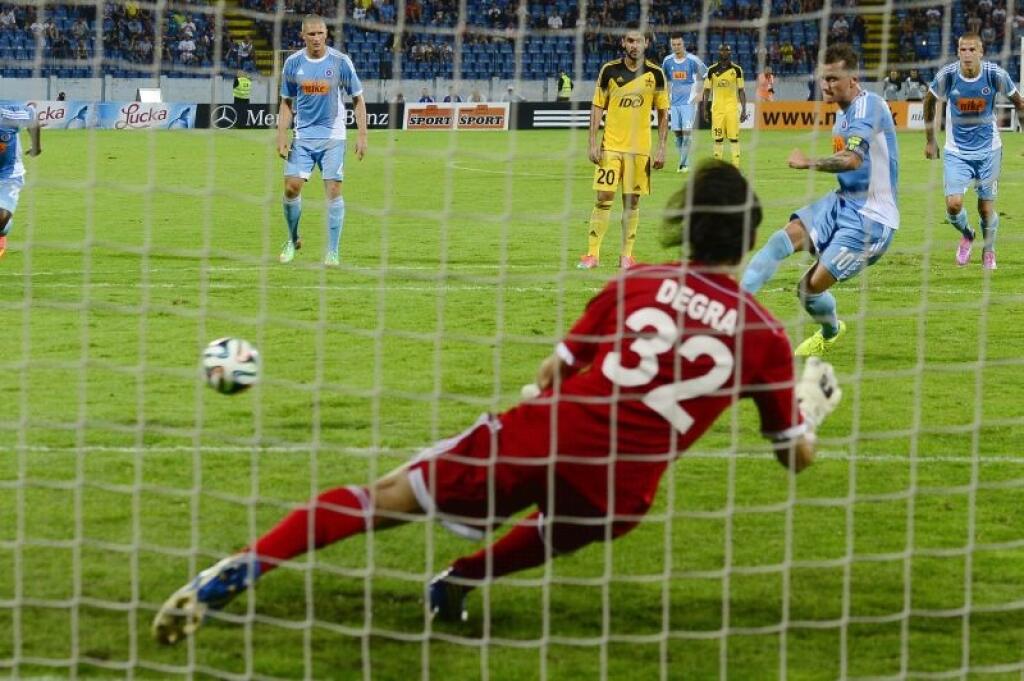 Na snímke vpravo v pozadí Igor Žofčák (Slovan) strieľa gól z pokutového kopu, v popredí brankár Matias Degra (Tiraspoľ) v úvodnom zápase 3. predkola Ligy majstrov ŠK Slovan Bratislava - Šerif Tiraspoľ (Moldavsko) 29. júla 2014 v Bratislave. FOTO TASR - Pavel Neubauer