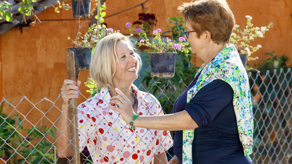 Two,Contented,Happy,Elderly,Ladies,Standing,Chatting,Together,In,The