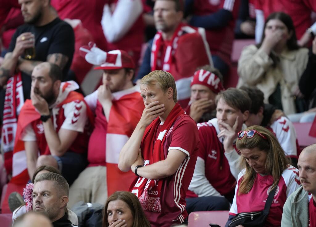 Dánski fanúšikovia reagujú po tom, čo skoloboval na trávniku dánsky futbalista Christian Eriksen počas zápasu základnej B-skupiny Dánsko - Fínsko na európskom šampionáte v Kodani v sobotu 12. júna 2021.