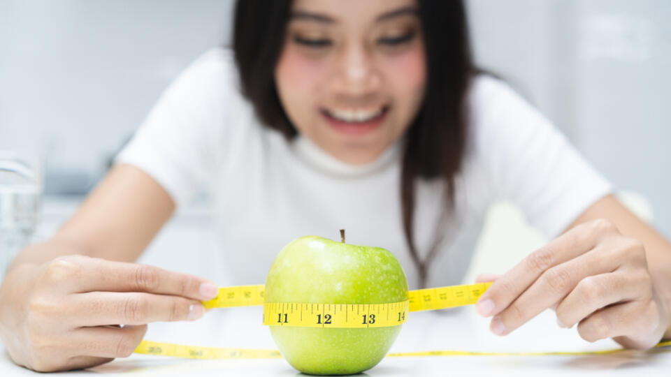Slimming,And,Dieting,Concept.,Woman,Measuring,Green,Apple.