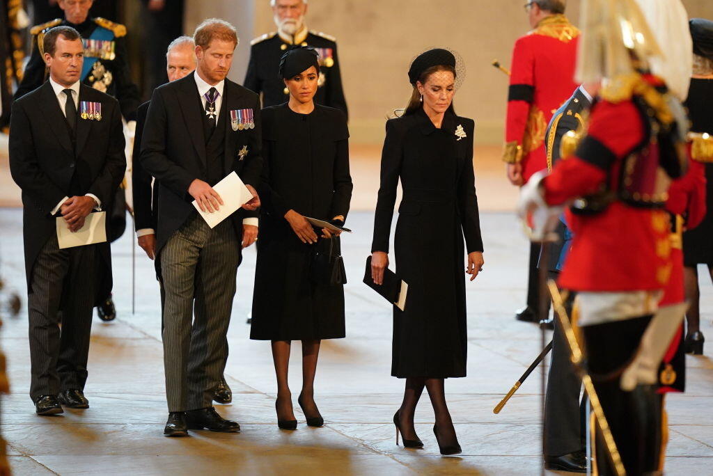 Rakva nesúca kráľovnú Alžbetu II je prenesená z Buckinghamského paláca do Westminsterského paláca. Na snímke môžete vidieť Megan Markle aj princeznú Kate.
