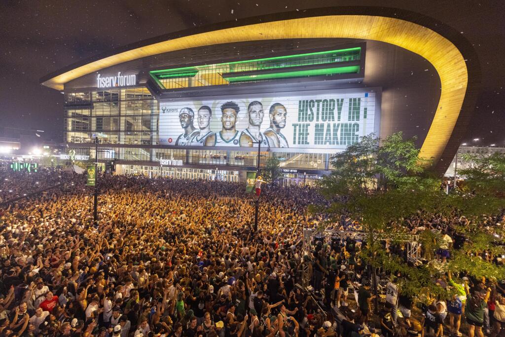 KK8 Milwaukee - Fanúšikovia Milwaukee Buck oslavujú po ich víťazstve v šiestom finálovom zápase zámorskej NBA proti Phoenixu 20. júla 2021 v Milwaukee. Basketbalisti Milwaukee Bucks získali po 50 rokoch svoj druhý titul v NBA, keď v šiestom finálovom stretnutí zvíťazili nad Phoenixom Suns 105:98 a triumfovali v sérii 4:2 na zápasy. FOTO TASR/AP
Fans cheer after the Milwaukee Bucks defeated the Phoenix Suns in Game 6 of the NBA basketball finals to win the NBA championship Tuesday, July 20, 2021