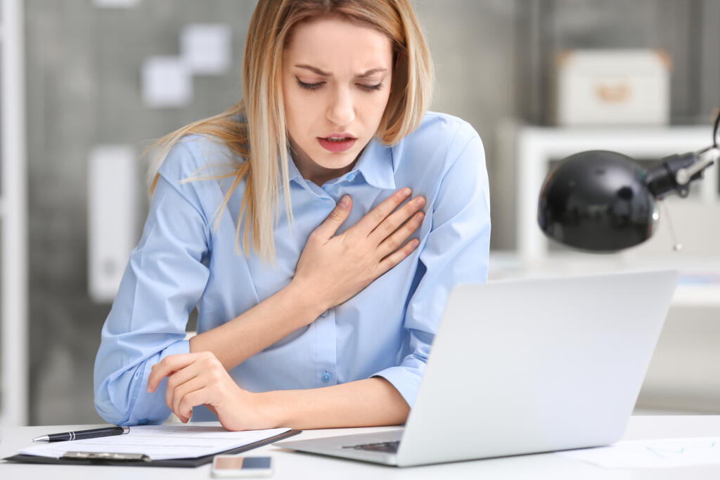 Young,Woman,Suffering,From,Chest,Pain,In,Office