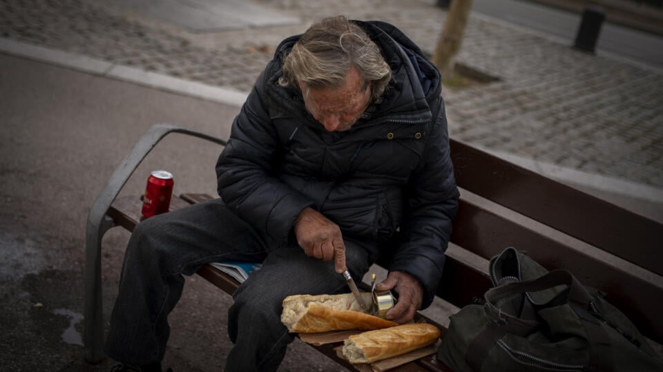 Na snímke bezdomovec si pripravuje sendvič k obedu v parku v centre španielskej Barcelony.