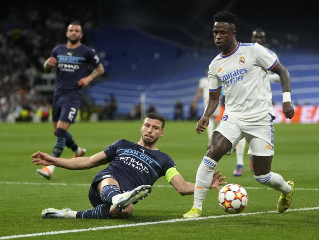 EBE 42 Madrid - Na snímke sprava hráč Realu Vinicius Junior a hráč Manchestru Ruben Dias v odvete semifinále Ligy majstrov vo futbale Real Madrid - Manchester City v Madride 4. mája 2022. FOTO TASR/AP
Real Madrid's Vinicius Junior, right, duels for the ball with Manchester City's Ruben Dias during the Champions League semi final, second leg soccer match between Real Madrid and Manchester City at the Santiago Bernabeu stadium in Madrid, Spain, Wednesday, May 4, 2022. (AP Photo/Manu Fernandez)