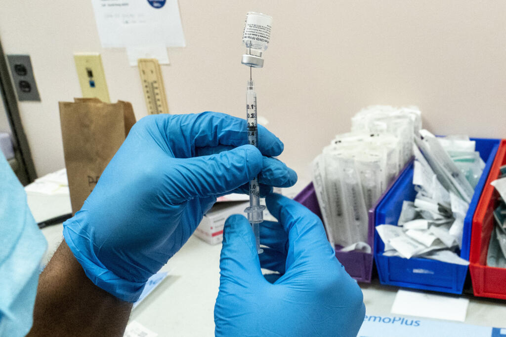 WA 1 archív New York - Na archívnej snímke z 18. februára 2021 lekár naťahuje injekčnou striekačkou z ampulky vakcínu proti ochoreniu COVID-10 od spoločností Pfizer/BioNTech vo vakcinačnom centre V New Yorku. Vakcína proti chorobe COVID-19 od konzorcia Pfizer/BioNTech má účinnosť 94 percent, pokiaľ ide o pokles symptomatických prípadov nákazy. Vyplýva to z recenzovanej štúdie, ktorej sa zúčastnilo 1,2 miliónov obyvateľov Izraela, informovala v stredu 24. februára 2021 agentúra AFP. FOTO TASR/AP
