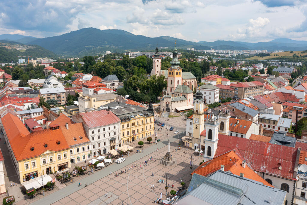 Na snímke z dronu Námestie SNP v Banskej Bystrici, v popredí vpravo Hodinová veža, za ňou budova a veža Barbakanu (mestský hrad) a celkom vzadu veža Kostola Nanebovzatia Panny Márie. Banská Bystrica, 19. augusta 2023 FOTO TASR - Michal Svítok