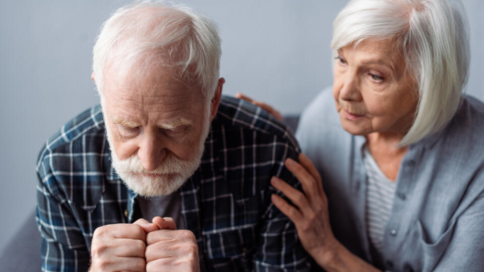 Worried,Senior,Woman,Touching,Husband,Suffering,From,Dementia,And,Sitting