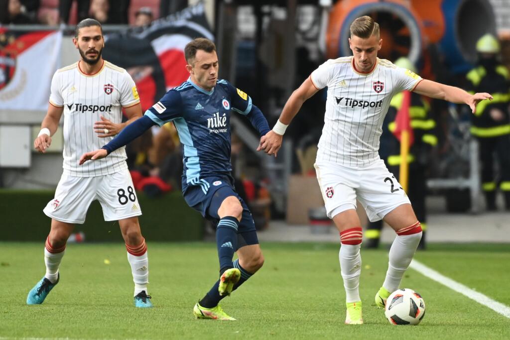 Na snímke zľava hráč Spartaka Kyriakos Savvidis, hráč Slovana Dejan Dražič a hráč Spartaka Filip Twardzik v zápase 11. kola futbalovej Fortuna ligy FC Spartak Trnava - ŠK Slovan Bratislava v Trnave v nedeľu 17. októbra 2021. FOTO TASR - Lukáš Grinaj