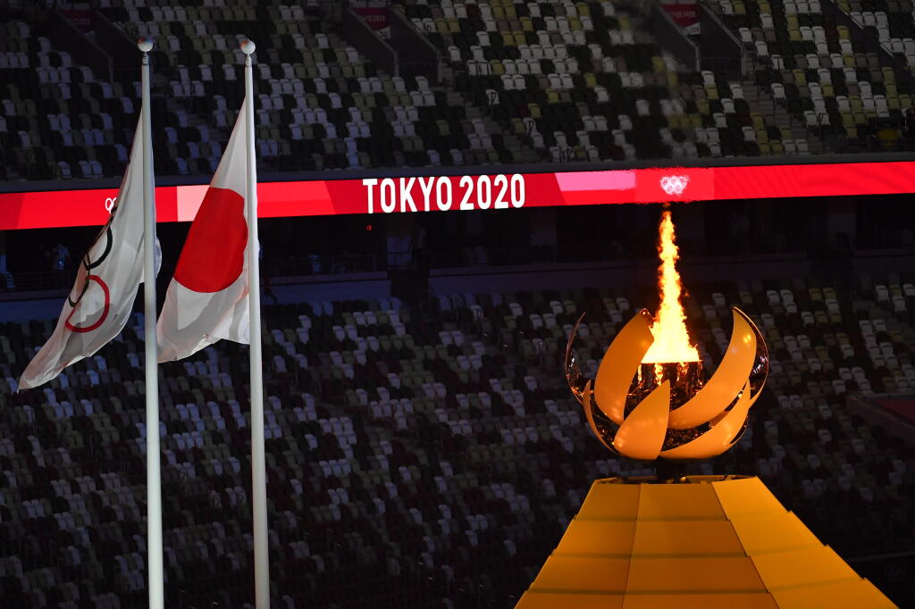 Vlajka Medzinárodného olympijského výboru (MOV), japonská vlajka a olympijský oheň, ktorý zapálila japonská tenistka Naomi Osaková počas otváracieho ceremoniálu na XXXII. letných olympijských hrách v Tokiu, 23. júla 2021.