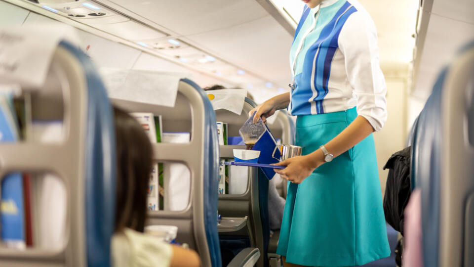 Flight,Attendant,Serving,Drinks,To,Passengers,On,Board.