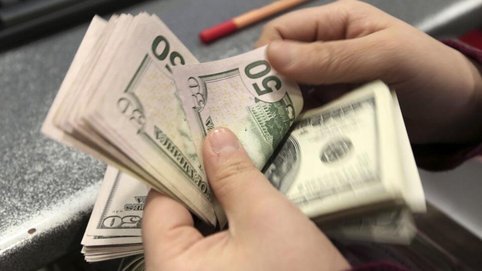In this photo taken Tuesday, Jan. 28, 2014, a woman counts U.S. dollar banknotes at a currency exchange office in Istanbul, Turkey. Turkey's central bank has sharply raised its key interest rate to 12 percent from 7.75 percent to try to stave off inflation and support the national currency, which has fallen sharply in recent weeks. The decision was taken late Tuesday at an emergency meeting the central bank called for after the currency, the lira, hit a record low. (AP Photo/Emrah Gurel)