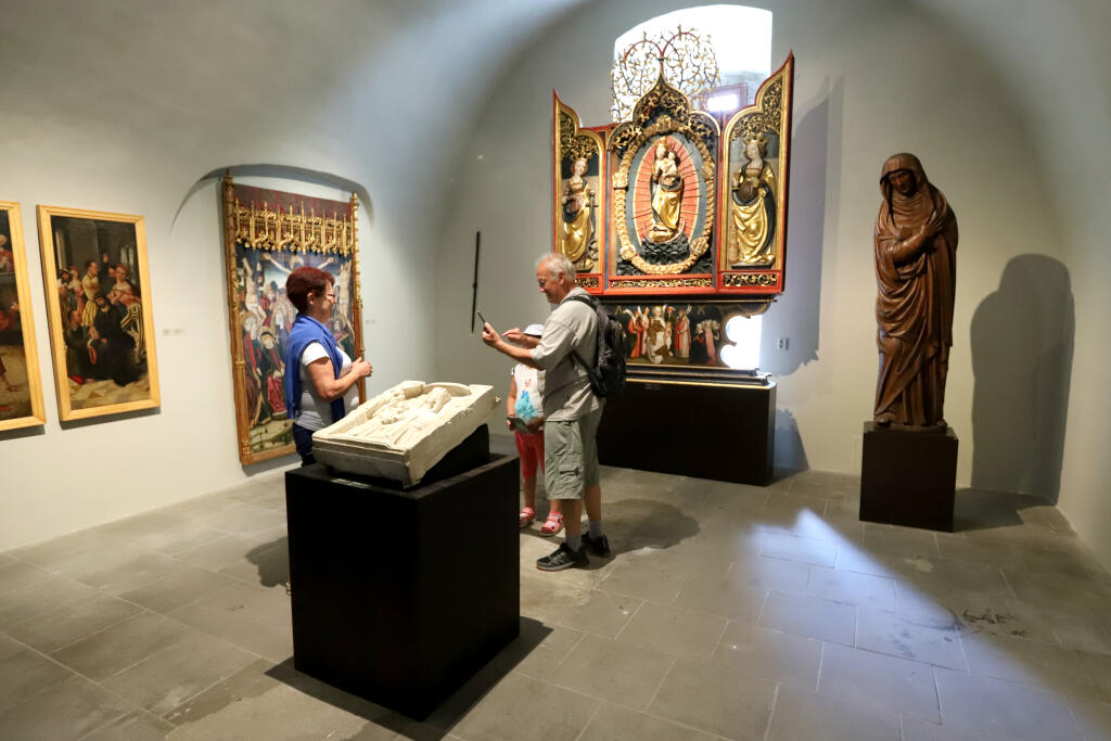 Slovenská národná galéria (SNG) na Zvolenskom hrade otvorila novú expozíciu gotického umenia. Expozícia predstavuje kolekciu stredovekého sochárstva a maliarstva na Slovensku jedinečnú počtom vystavených diel, ako aj koncentráciou na obdobie 14. až 16. storočia. Vystavených je viac než 70 sôch a obrazov. Na snímke návštevníci stoja pri oltári Ružencovej Panny Márie z Korutánska pochádzajúci okolo roku 1520 počas výstavy na Zvolenskom hrade v utorok 26. júla 2022. FOTO TASR - Ján Krošlák