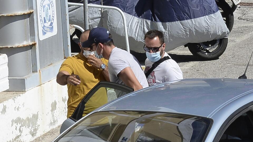 Kapitán anglického futbalového klubu Harry Maguire (uprostred) prichádza v sprievode policajtov na policajnú stanicu na gréckom ostrove Syros v piatok 21. augusta 2020. Maguire skončil na gréckom ostrove Mykonos v putách miestnej polície. Stalo sa tak vo štvrtok v skorých ranných hodinách po incidente pred jedným z miestnych barov. Maguire sa podľa britských médií dostal do roztržky s ďalšími anglickými turistami a potom sa správal agresívne a vulgárne aj voči zasahujúcim policajt