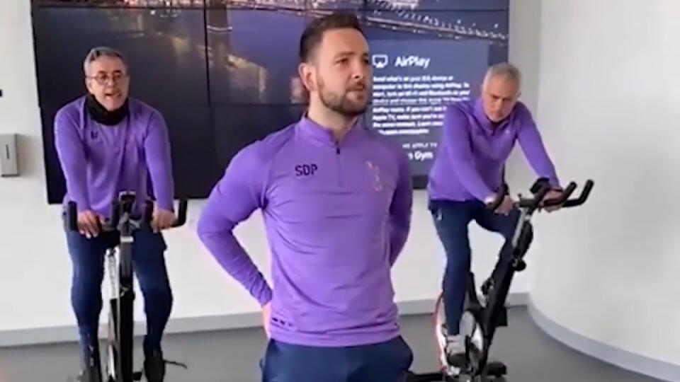 José Mourinho sleduje tréning svojho tímu zo stacionárneho bicykla.