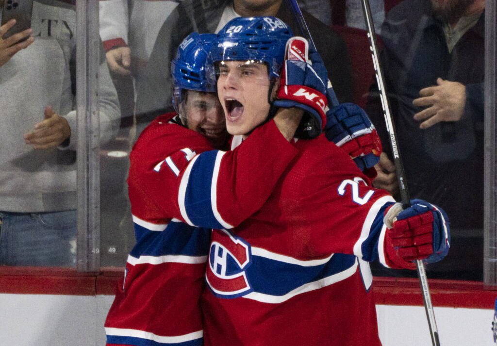 Slovenský hokejový reprezentant v drese Montrealu Canadiens Juraj Slafkovský (vpravo) sa teší so spoluhráčom Jakeom Evansom po strelení premiérového gólu v NHL v domácom zápase proti Arizone Coyotes v Montreale vo štvrtok 20. októbra 2022.