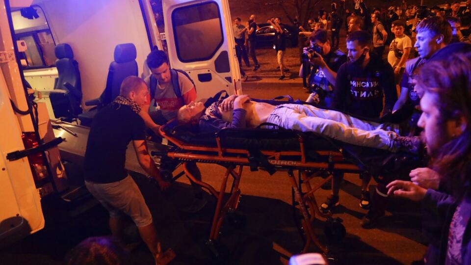 WA 4 Minsk - Záchranári nakladajú zranenú osobu do sanitky počas protestu proti výsledkom prezidentských volieb v bieloruskej metropole Minsk v nedeľu 9. augusta 2020. V centre bieloruskej metropoly Minsk vypukli v nedeľu večer násilné strety medzi políciou a demonštrantmi, ktorí na výzvu opozície vyšli do ulíc, aby sa domáhali transparentného sčítania hlasov odovzdaných v nedeľných prezidentských voľbách. FOTO TASR/AP
Protesters help paramedics to carry a wounded person into an ambulance afte