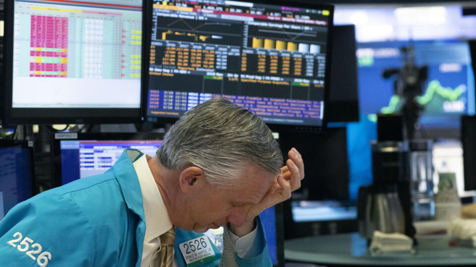 WA 22 New York - Burzový maklér reaguje počas obchodovania na newyorskej burze v stredu 18. marca 2020. Wall Street v stredu pokračovala v páde. Popoludní padol širší index S&P 500 o 7 %, čo opäť spôsobilo automatické zastavenie obchodovania na 15 minút. Kľúčový americký index Dow Jones Industrial Average sa o 18.17 h SEČ nachádzal s mínusom 8,66 % alebo 1840,15 bodu na 19.397,23 bodu.FOTO TASR/AP
A trader holds his hand to his head after trading was halted at the New York Stock Exchange, Wedne