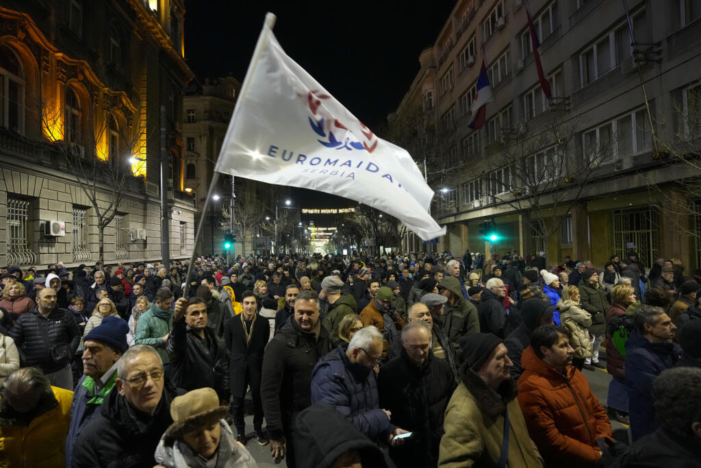 Demonštrant máva vlajkou s nápisom: „EUROMAIDAN Srbsko“ počas zhromaždenia v centre Belehradu.