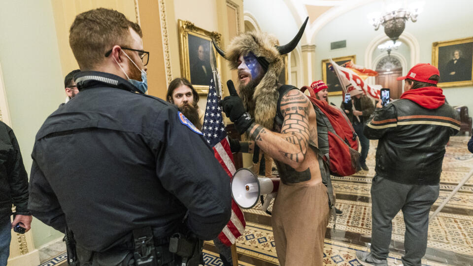 KK44 Washington - Na archívnej snímke zo 6. januára 2021 priaznivci amerického prezidenta Donalda Trumpa v kolízii s políciou v budove Kapitolu vo Washingtone. Uprostred Jacob Chansley zo štátu Arizona oblečený ako šaman s rohami a kožušinou. Americká prokuratúra je teraz presvedčená, že stúpenci prezidenta Donalda Trumpa plánovali minulý týždeň počas obliehania budovy Kongresu