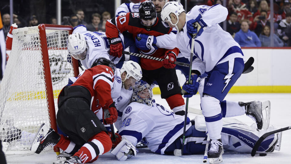 Na snímke tretí sprava s číslom 90 slovenský útočník Devils Tomáš Tatar, dole ruský brankár Tampy Andrej Vasilevskij v zápase hokejovej NHL New Jersey Devils - Tampa Bay Lightning.