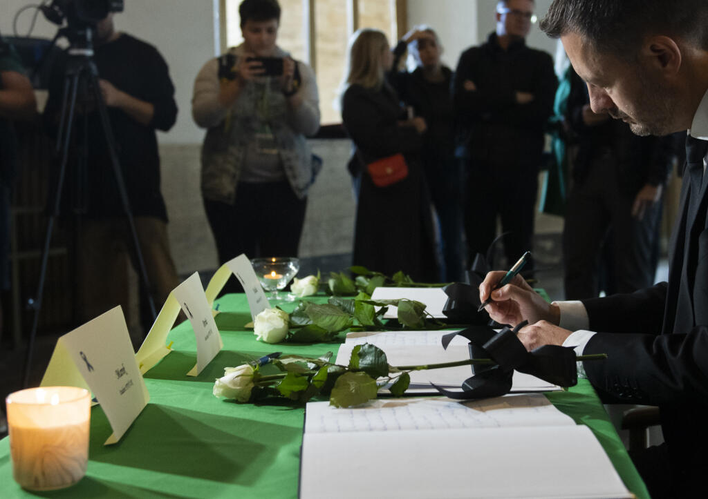 Na snímke vpravo predseda vlády SR Eduard Heger (OĽaNO) sa zapísal do kondolenčných kníh na pamiatku obetí nedeľnej tragickej dopravnej nehody v aule Univerzity Komenského v Bratislave v pondelok 3. októbra 2022. Nehoda si vyžiadala piatich mŕtvych a päť zranených. FOTO TASR - Martin Baumann