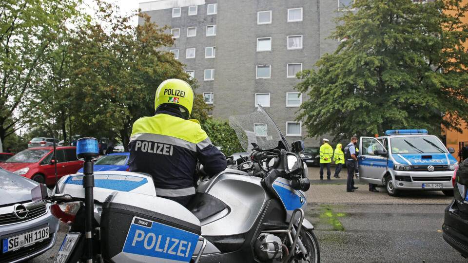 Policajti stoja pred vchodom do bytového domu v nemeckom meste Solingen v spolkovej krajine Severné Porýnie-Vestfálsko.