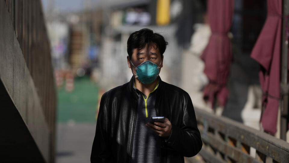 WA 8 archív Peking - Na archívnej snímke z 8. decembra 2022 muž s respirátorom na tvári a mobilným telefónom v ruke kráča ulicami v Pekingu. Čína oznámila, že od utorka 13. decembra ukončí prevádzku mobilnej aplikácie, určenej na sledovanie kontaktov v kontexte šírenia ochorenia Covid-19. Čína pristupuje k tomuto kroku len niekoľko dní po tom, čo oznámila koniec rozsiahlych lockdownov a povinnej karantény v štátnych zariadeniach. Najľudnatejšia krajina sveta takisto uvoľnila pravidlá povinného