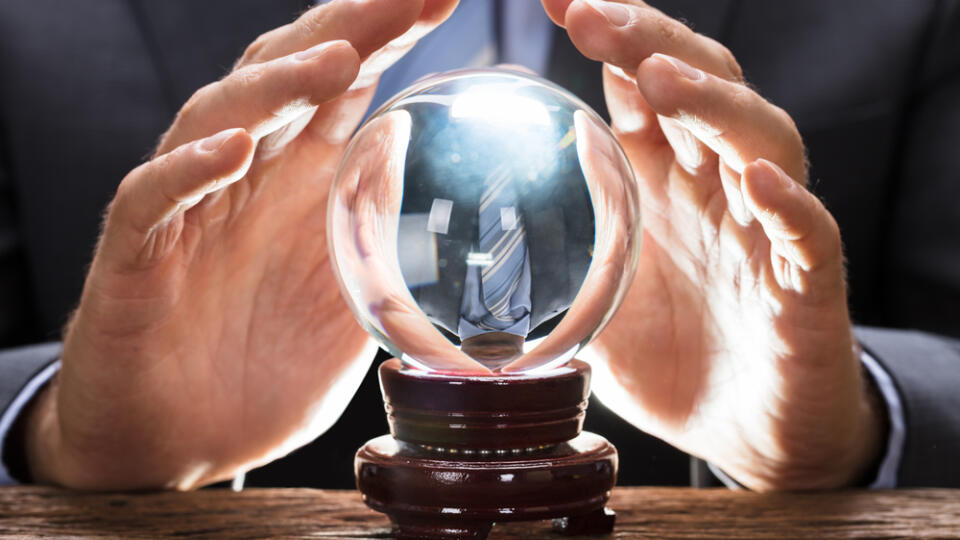 Midsection,Of,Businessman,Covering,Crystal,Ball,At,Wooden,Table