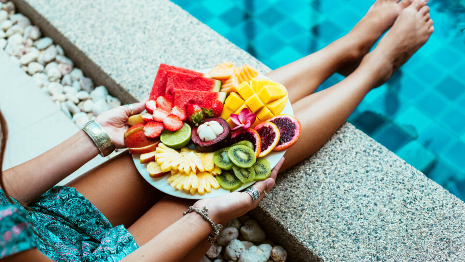 Girl,Relaxing,And,Eating,Fruit,Plate,By,The,Hotel,Pool.