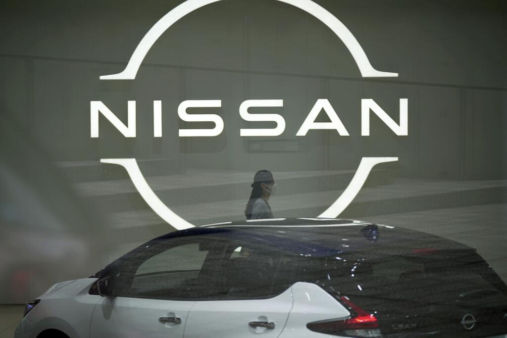 KK32 Jokohama - Zamestnankyňa kráča okolo loga spoločnosti Nissan 12. mája 2022 v Jokohame. Japonská automobilka Nissan vo štvrtok oznámila, že v uplynulom finančnom roku 2021/2022, ktorý sa skončil 31. marca, sa dostala z červených čísiel a vykázala zisk, prvý po troch rokoch. Odôvodnila to úsporami nákladov a pozitívnymi podmienkami na trhu v USA. FOTO TASR/AP
A staff walking near a Nissan logo at Nissan headquarters is seen though a window Thursday, May 12, 2022, in Yokohama near Tokyo. Japan