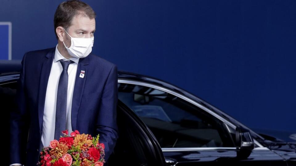 Slovakia's Prime Minister Igor Matovic carries a bouquet of flowers as he arrives for an EU summit in Brussels, Friday, Oct. 16, 2020. European Union leaders meet for the second day of an EU summit, amid the worsening coronavirus pandemic, to discuss topics on foreign policy issues