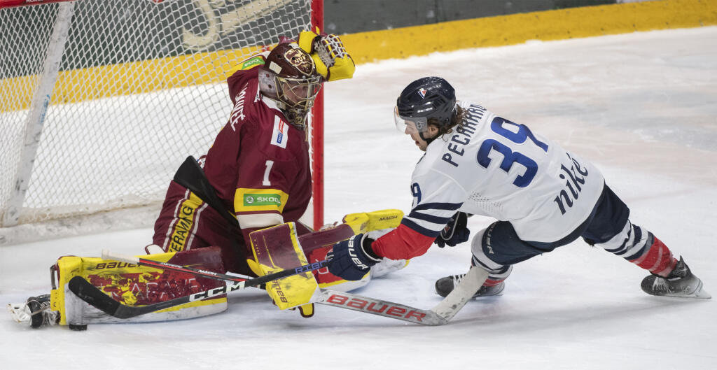 Na snímke sprava Liam Pecararo (Slovan) a vľavo brankár Connor Lacouvee (Trenčín) v zápase 20. kole hokejovej Tipos extraligy medzi HC Slovan Bratislava - HK Dukla Trenčín v Bratislave v piatok 25. novembra 2022.